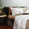 Biancheria letto_GUZZINI_OSAMA COMPLETO LETTO LINEA BOTANICAL SHADE_STAMPA COUNTRY VIBES_COL. ROASTED CASHEW_